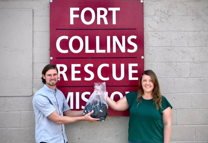 Old Town Media Account Manager passing off a donation of hand sanitizers to the fort collins rescue mission