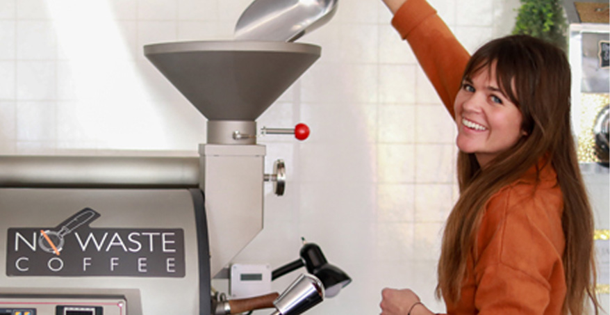 woman smiling and putting coffee in a machine